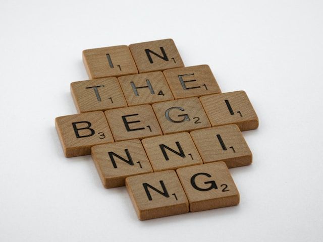 wood tiles spelling out "in the beginning"