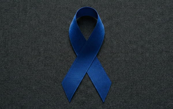 Blue colon cancer awareness ribbon on a dark textured background